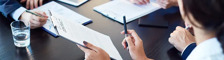 lawyer handing a clip board for a client to sign