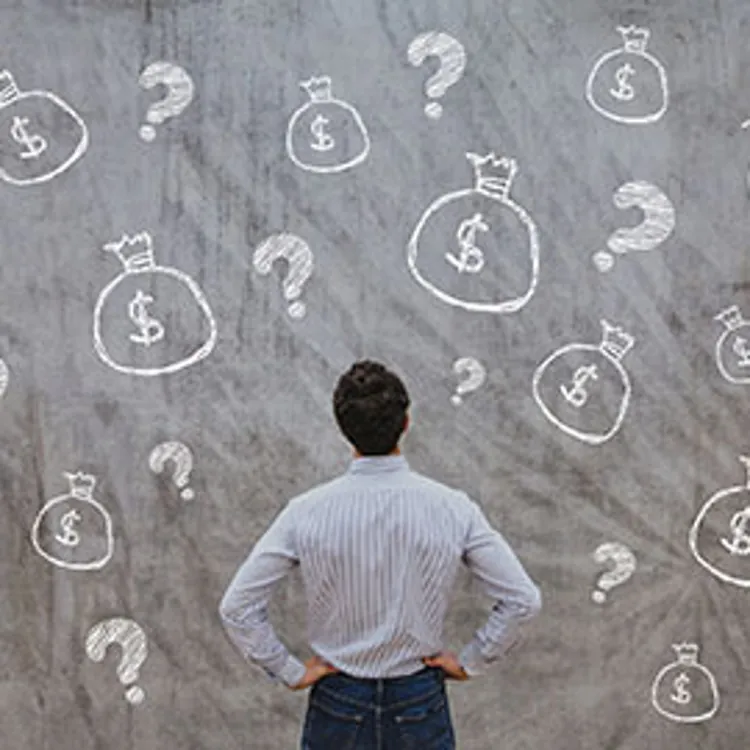 a man facing a large chalkboard with drawings of question marks and money bags with dollar signs