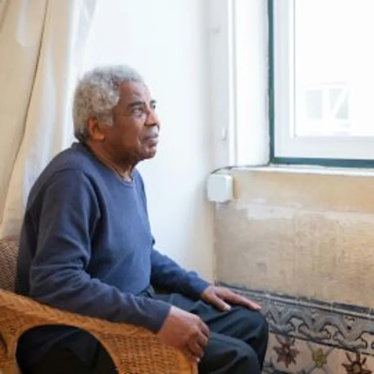 older man sitting by a window
