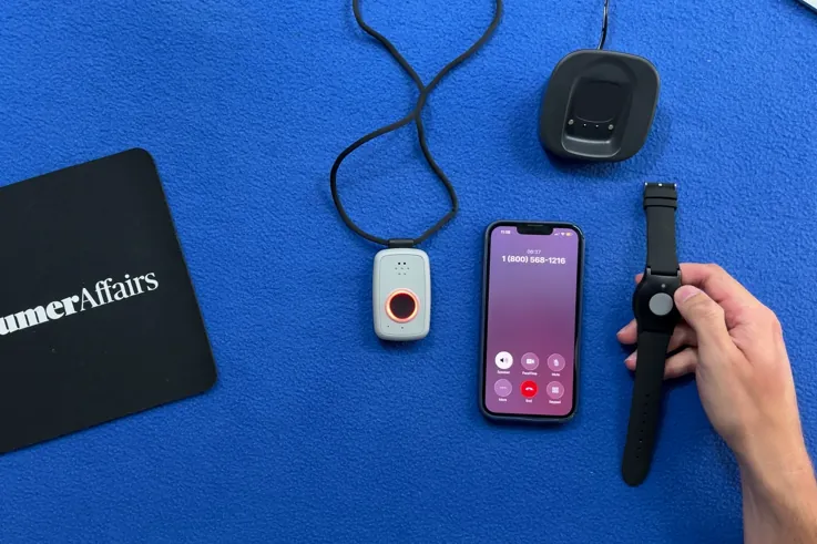 ADT On-the-Go pendant with its ring lit red beside a phone showing an active call