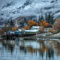 houses along a river in winter with mountains in the distance
