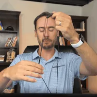 Chris Kolmar pulling the LifeBeacon lanyard over his head and settling the pendant on his chest