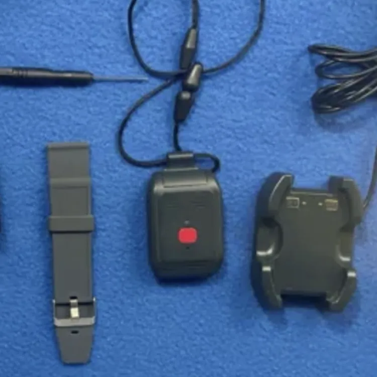 Medical alert device kit with wristband, lanyard, charging cable, screwdriver, and box on blue surface