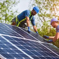 workers installing solar panels on a roof