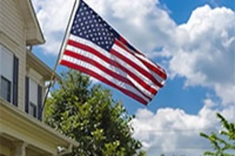 house with american flag displayed on top of a portico