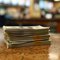 a stack of dollar bills on a counter