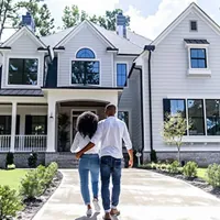 a couple in front of a house