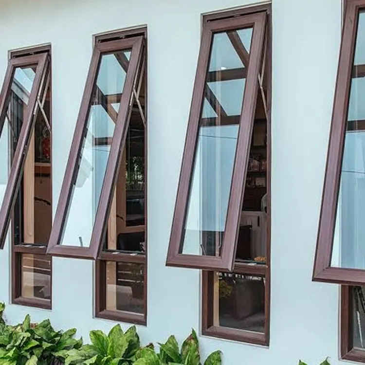Brown-framed glass windows tilted open on a white wall above a row of green plants