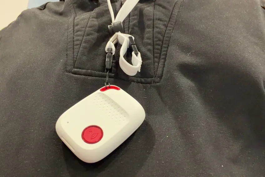 SOS All-in-One 2 pendant hanging from its lanyard on a dark sweatshirt