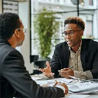 two men sitting across each other and talking