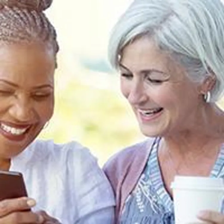 two senior women looking at smartphone