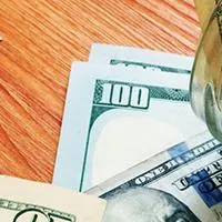 cash in glass jar labeled emergency fund