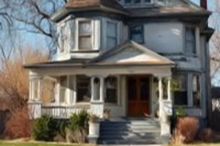 white two-storey house with a front yard