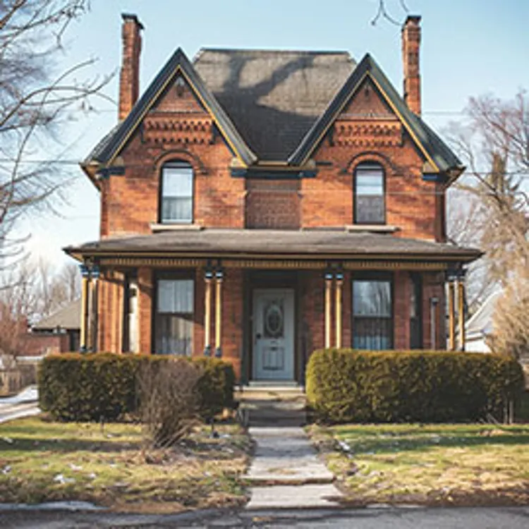 red brick two-story house with a front yard
