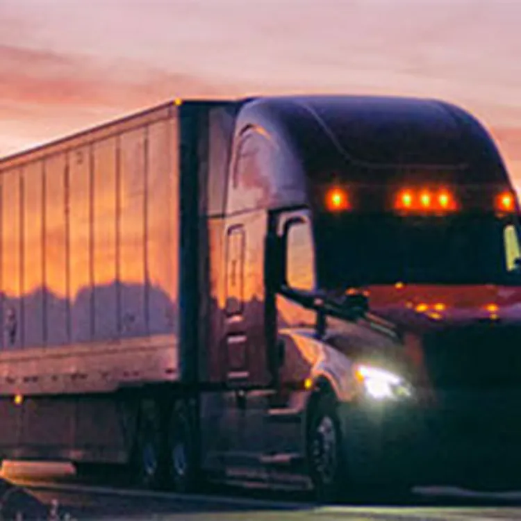 huge moving trucks on the highway amid sunset sky