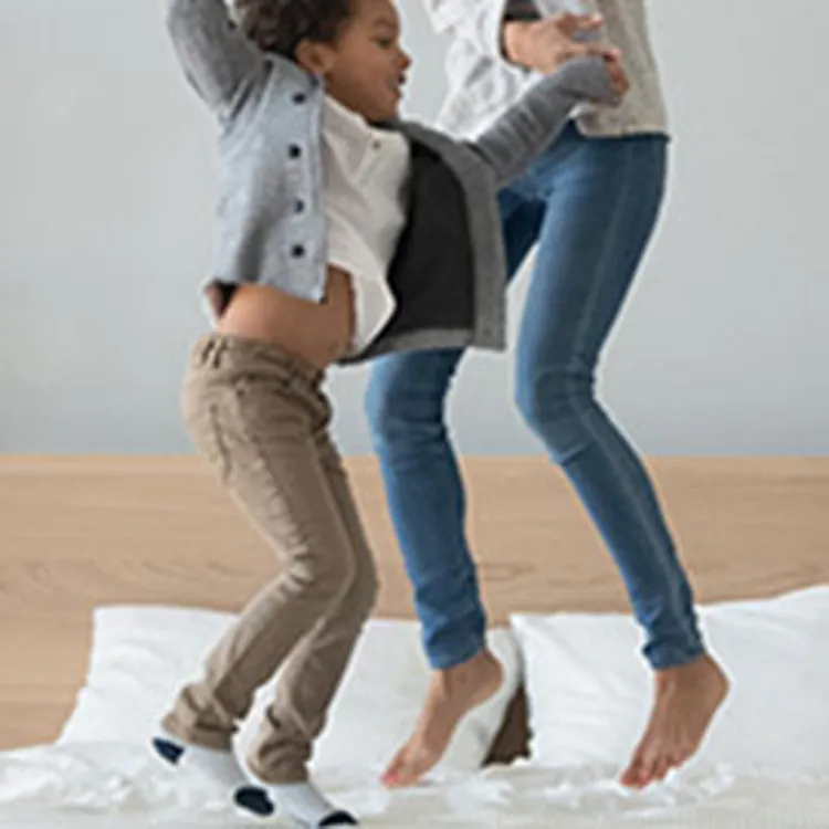 mom and son jumping on bed