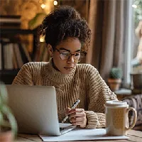 woman with laptop taking notes