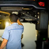 technician checking the underneath parts of the car