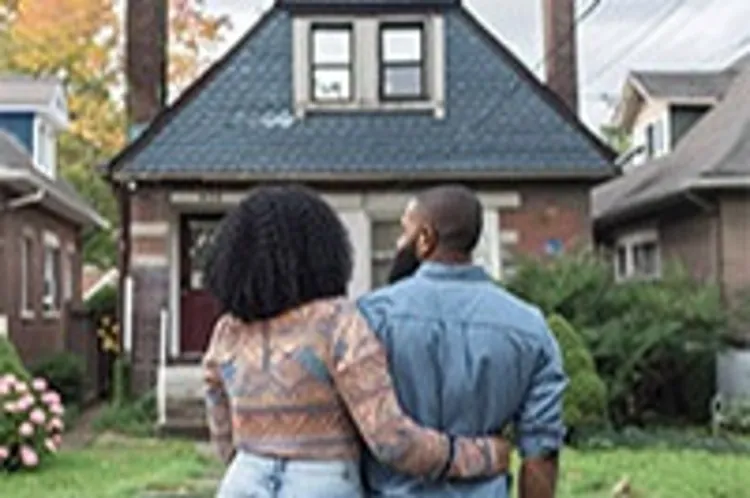 back view of couple looking at a single detached house
