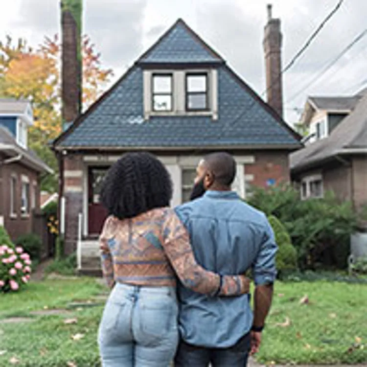 back view of couple looking at a single detached house