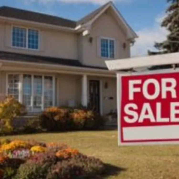 house with a for sale sign in the front yard
