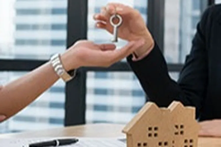 woman handing a key to another person