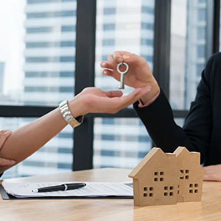 woman handing a key to another person