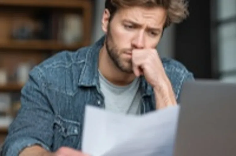 man looking worried while balancing budget