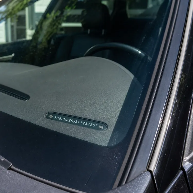 Closeup of a car dashboard showing a VIN number through the windshield