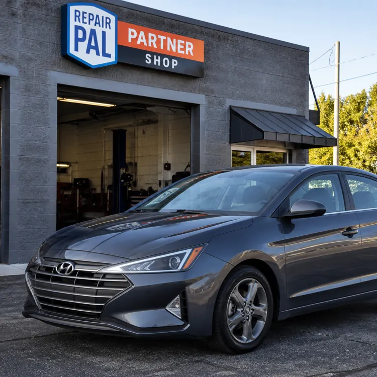 Gray Hyundai sedan parked in front of an auto repair shop with RepairPal Partner Shop sign