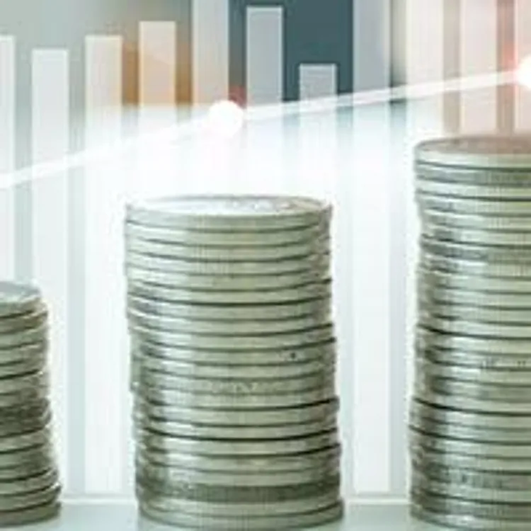 stacks of coins increasing in height with fluctuating bar graph in the background