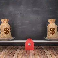 seesaw scale with dollar money sacks on chalkboard background