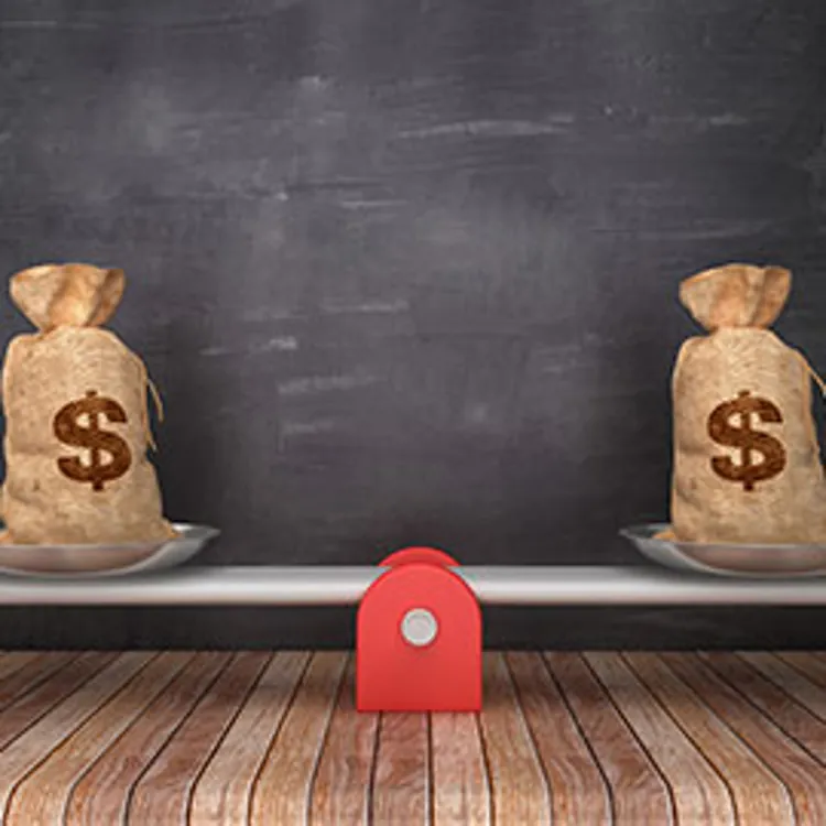 seesaw scale with dollar money sacks on chalkboard background