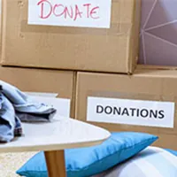 woman sorting and boxing clothes for donation