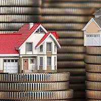 little houses sitting on stacks of coins