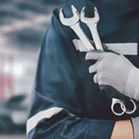 mechanic holding wrenches in garage