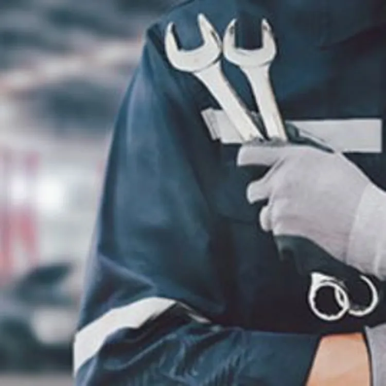 mechanic holding wrenches in garage