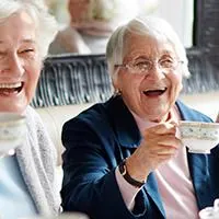 group of older ladies laughing over coffee