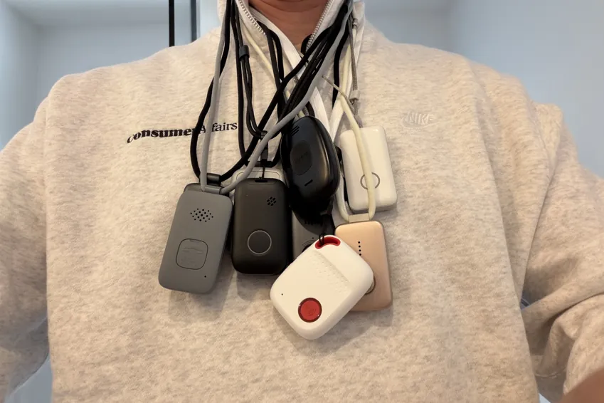 Chris Kolmar wearing nine medical alert pendants on lanyards around his neck over a white sweater