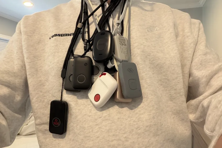 Chris Kolmar wearing nine medical alert pendants on lanyards around his neck over a white sweater
