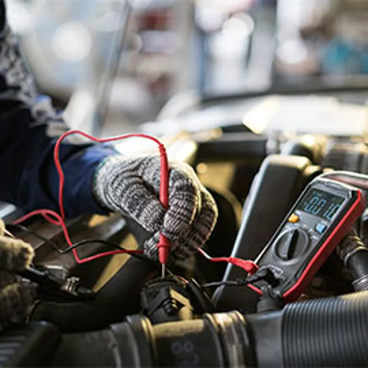mechanic measuring electric voltage for car repair