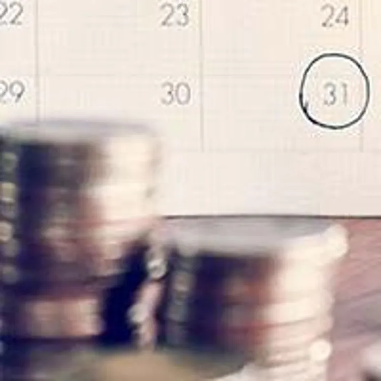 coins and calculator in front of calendar