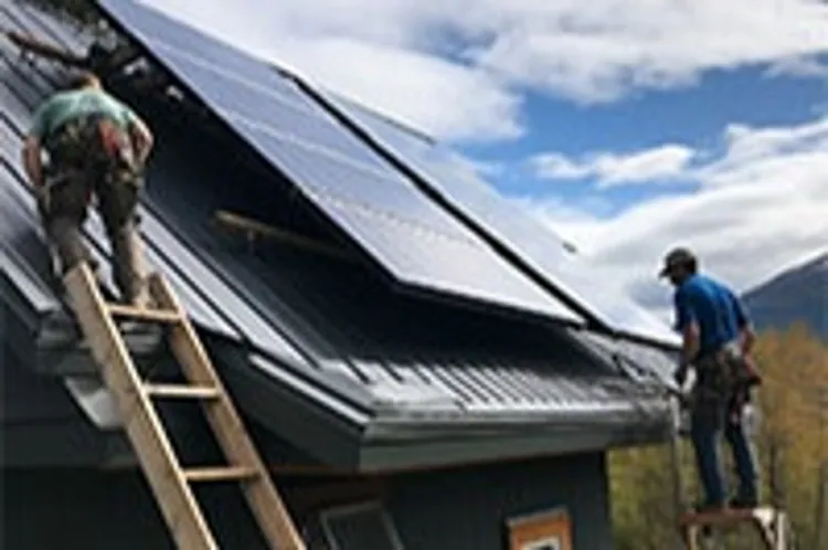two men installing solar panels on the roof of a home in Alaska