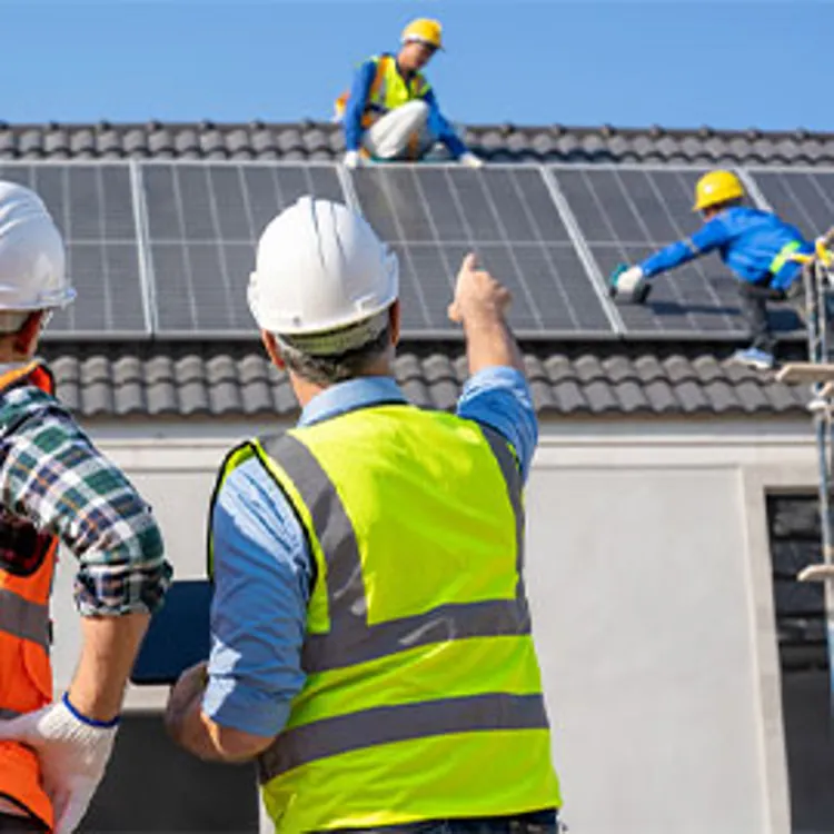 engineers overseeing techs installing solar panels on roof