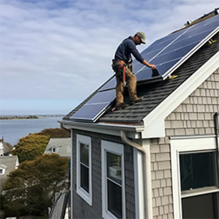 tech fixing solar panel on roof of home by the seaside