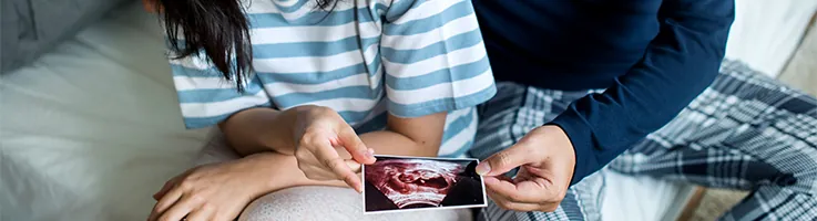 couple holding baby ultrasound image