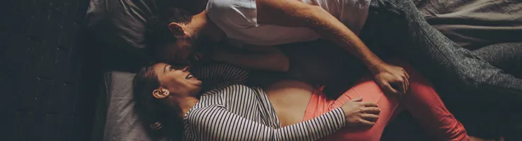 pregnant couple laying in bed