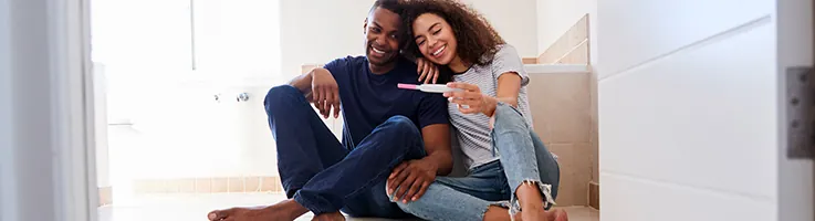 couple smiling at pregnancy test