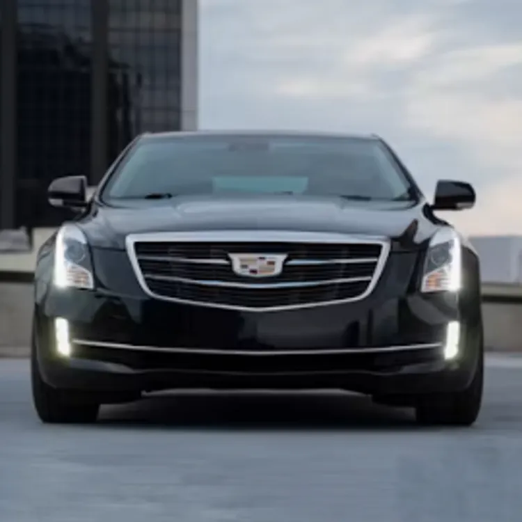 A black luxury sedan parked in a city with buildings in the background