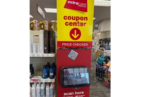 Coupon center kiosk with price checker and scan screen in a retail store aisle